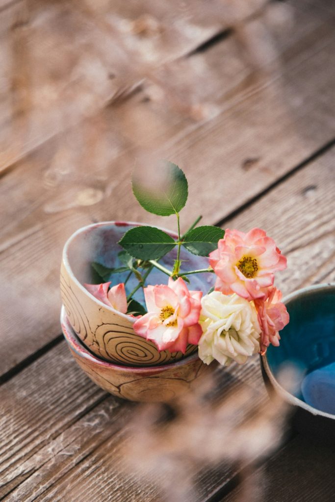pink-and-yellow-flower-in-blue-ceramic-bowl-eym3vfvdt1g